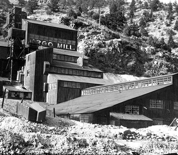 Black and white image of the historic Argo Mill situated on a hillside.