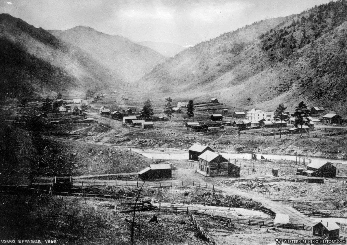 Aerial view of Idaho Springs in 1866, featuring a small settlement surrounded by mountains.