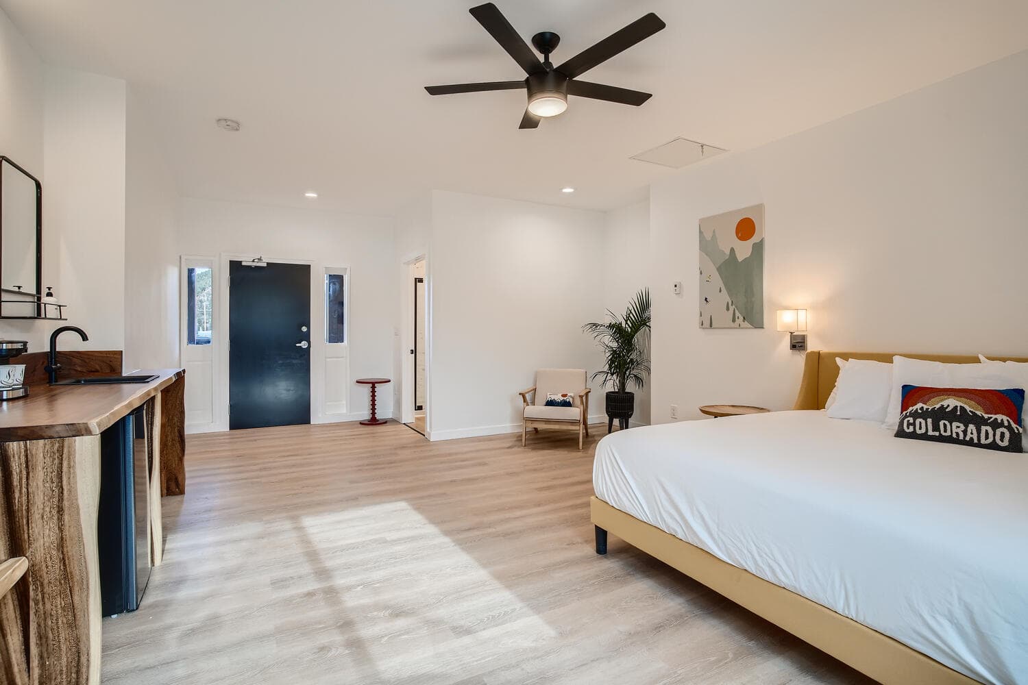 A modern hotel room featuring a queen bed, minimalist decor, and a welcoming atmosphere.